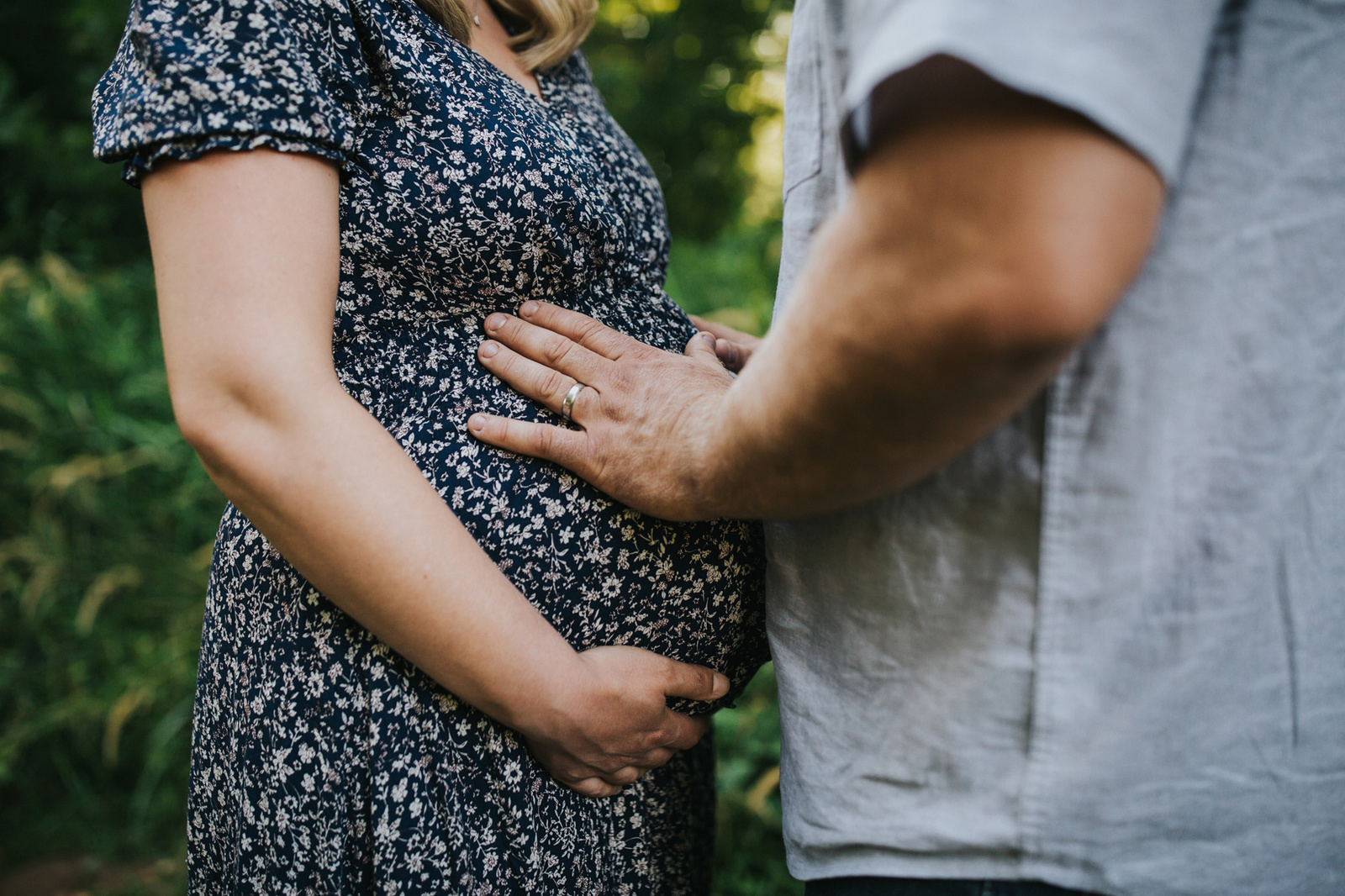 Zoom in on dad's hands touching mom's belly during a Yamhill, OR maternity session.